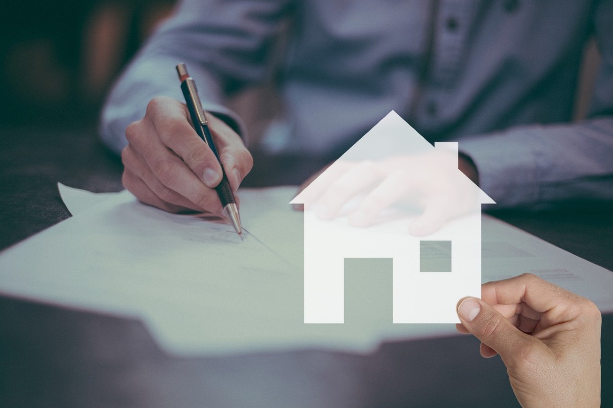 Un hombre firmando documentos de vivienda